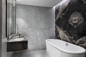 Reges, a Luxury Collection Resort & Spa, Cesme في تشيشمي: حمام مع حوض أبيض ومغسلة