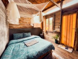 um quarto com uma cama num chalé de madeira em Lang Thang House em Kon Von Kla