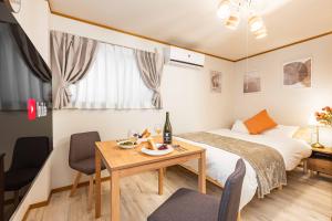 a hotel room with a bed and a table and chairs at アリタビル大国 in Osaka