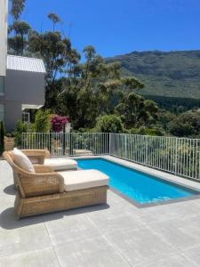 a patio with a couch and a swimming pool at Elite Retreats - Hillside Exclusive Villa 1 - load shedding backup in Cape Town