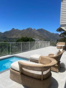 a patio with wicker chairs and a swimming pool at Elite Retreats - Hillside Exclusive Villa 1 - load shedding backup in Cape Town