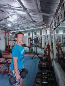 a man standing in a gym with weights at QUICKSHIELD HOMESTAY in Naga