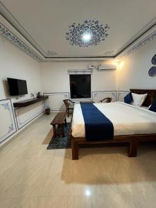 a bedroom with a bed and a flat screen tv at Hem Vilas in Sawāi Mādhopur