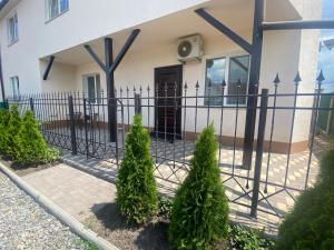een hek voor een huis met bomen bij Apartments in Pyrogovo in Vinnytsya