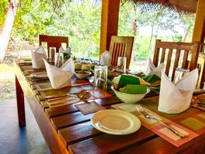 a wooden table with plates and utensils on it at Ceylon Amigos Eco Resort in Sigiriya