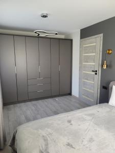 ein Schlafzimmer mit einem großen Bett und einem Schrank in der Unterkunft Maironio apartamentai in Radviliškis