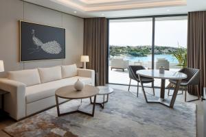 een woonkamer met een witte bank en tafels bij Reges, a Luxury Collection Resort & Spa, Cesme in Çeşme