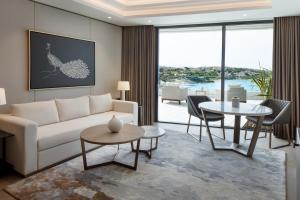 a living room with a white couch and tables at Reges, a Luxury Collection Resort & Spa, Cesme in Çeşme