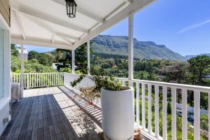 a white porch with a view of the mountains at Exclusive Tree Cottage with hot tub - Power Back-up in Cape Town