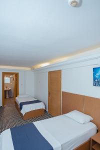 a hotel room with two beds and a bathroom at Deniz Pansiyon in İzmir