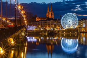 a city lit up at night with a ferris wheel at Maison d'hôtes City Break MIRADOUR in Bayonne