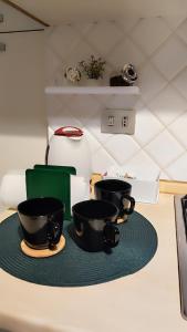 two black cups sitting on a counter top at Porta Venezia Home in Milan