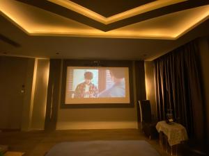 a room with a projection screen on a wall at M&H Cinema in Ho Chi Minh City
