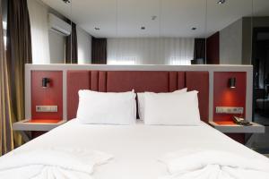 een slaapkamer met een groot wit bed met een rood hoofdeinde bij Voir Hotel Pera in Istanbul