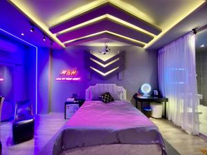 a purple bedroom with a large bed and a desk at M&H Cinema in Ho Chi Minh City