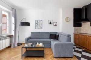 - un salon avec un canapé bleu et une table dans l'établissement Rent like home - Rycerska 4/6 II, à Varsovie