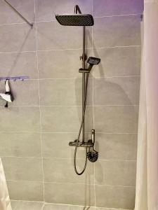 a shower with a shower head in a bathroom at M&H Cinema in Ho Chi Minh City