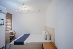 a bedroom with a bed and a desk in a room at Deniz Pansiyon in İzmir