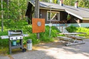 einen Grill und einen Picknicktisch vor einem Haus in der Unterkunft Rukajärven Lomamajat Apartment 5 in Kuusamo
