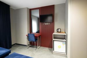 a hotel room with a desk and a television on a wall at Voir Hotel Pera in Istanbul