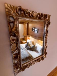 a mirror on a wall with a bed in a room at MANNI Gästehaus in Mayrhofen