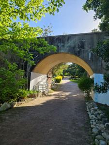 a stone bridge over a path with a road at The Riverdeck Accommodation and Backpackers in Knysna