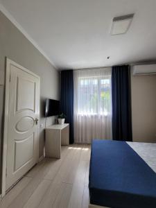 ein Schlafzimmer mit einem blauen Bett und einem Fenster in der Unterkunft Sky hotel KG in Bischkek