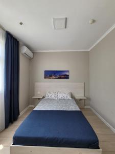 Un dormitorio con una cama grande con una manta azul. en Sky hotel KG, en Bishkek