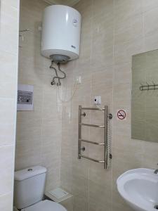 un baño con inodoro y lavabo en Sky hotel KG, en Bishkek