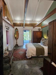 a bedroom with a bed and a table and a mirror at The Riverdeck Accommodation and Backpackers in Knysna