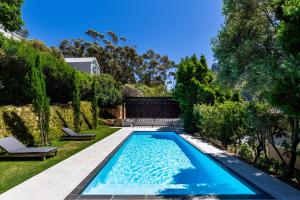 a swimming pool in the yard of a house at Exclusive Tree Cottage with hot tub - Power Back-up in Cape Town