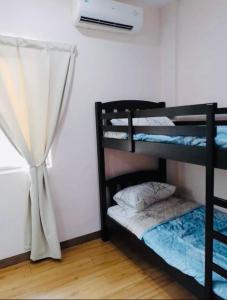 a room with two bunk beds and a window at Hostel ABC in Seri Kembangan