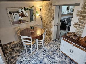 濱海雅爾的住宿－La Maison du pêcheur - Jacuzzi，一间铺有瓷砖地板并配有桌椅的用餐室