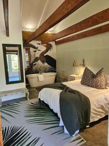 a bedroom with a large bed and a bath tub at The Riverdeck Accommodation and Backpackers in Knysna