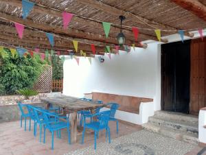 a patio with a wooden table and chairs and flags at Villa Aguacate in Nerja