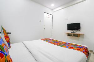 a small bedroom with a bed and a tv at FabExpress Blue Stone in Surat