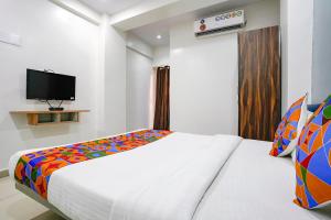 a bedroom with a bed and a tv on the wall at FabExpress Blue Stone in Surat