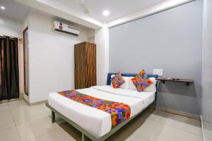 a bedroom with a bed with a colorful blanket on it at FabExpress Blue Stone in Surat