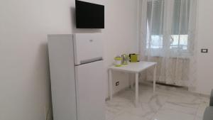 eine Küche mit einem weißen Kühlschrank und einem kleinen Tisch in der Unterkunft Casa vacanze Domus Magnifica in Rom