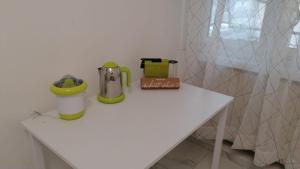 Una mesa blanca con una cafetera. en Casa vacanze Domus Magnifica en Roma