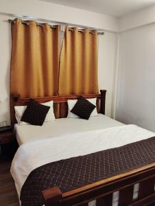 a bedroom with a large bed with a curtain at Hotel White Lotus in Darjeeling