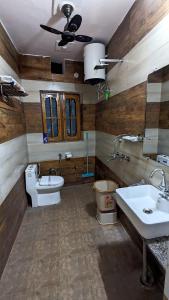 a bathroom with two sinks and a toilet and a ceiling at Prakriti Homestay in Roorkee