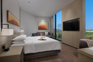 a hotel room with a bed and a flat screen tv at Hyatt Place Changsha Airport in Changsha