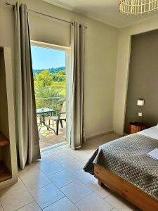 a bedroom with a bed and a view of a patio at Harma Corfu in Sidari +45 photos