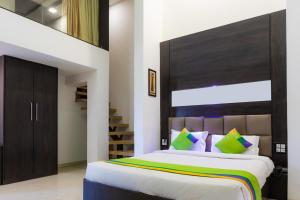 Schlafzimmer mit einem großen Bett mit einem Kopfteil aus Holz in der Unterkunft Treebo Trend The Blue Roof in Kolshet