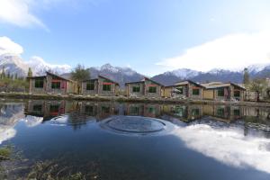 a row of houses sitting next to a body of water at LOKAL Rooms x Skardu (Katpana Retreat) in Skardu