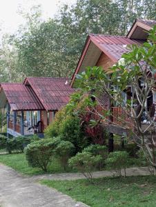 una casa con techo rojo junto a un patio en Mookanda bungalow, en Ko Yao Noi