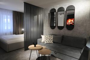 a living room with a couch and a bed and mirrors at Apartman 105 Vucko Jahorina in Jahorina