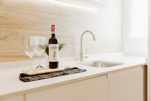 eine Flasche Wein und zwei Gläser auf der Küchentheke in der Unterkunft Apartamento Plaza Logroño in Logroño