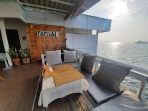 una mesa y sillas en la cubierta de un barco en บ้านฟ้าใส รีสอร์ท เกาะล้าน en Ko Larn